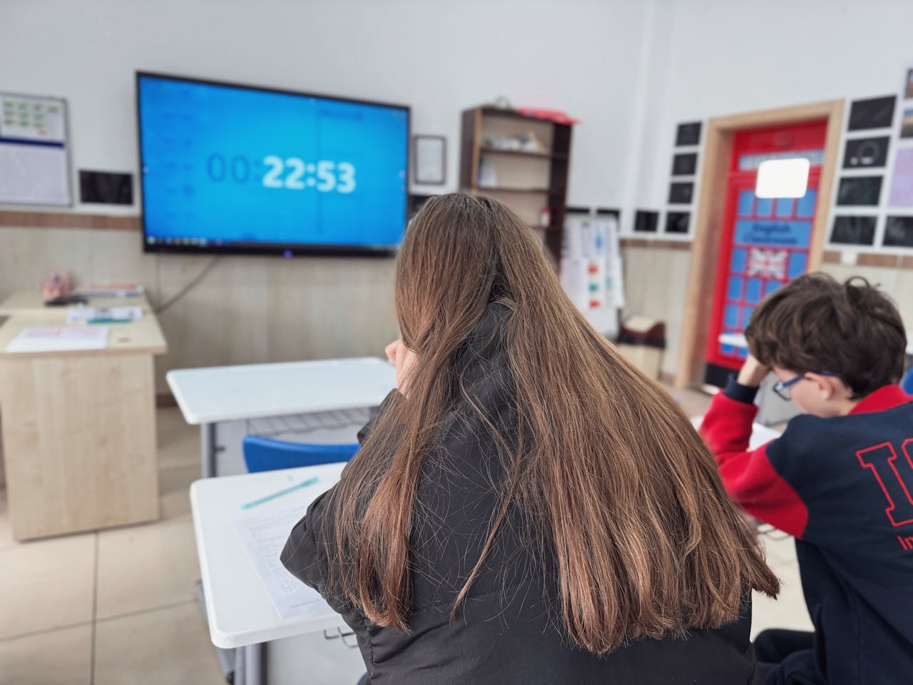 Students concentrating in a modern classroom with a digital timer on screen.